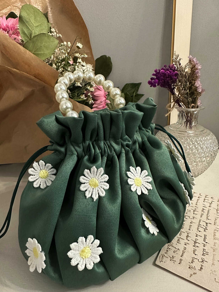 borsa sartoriale in raso verde con margherite bianche cucite in rilievo 