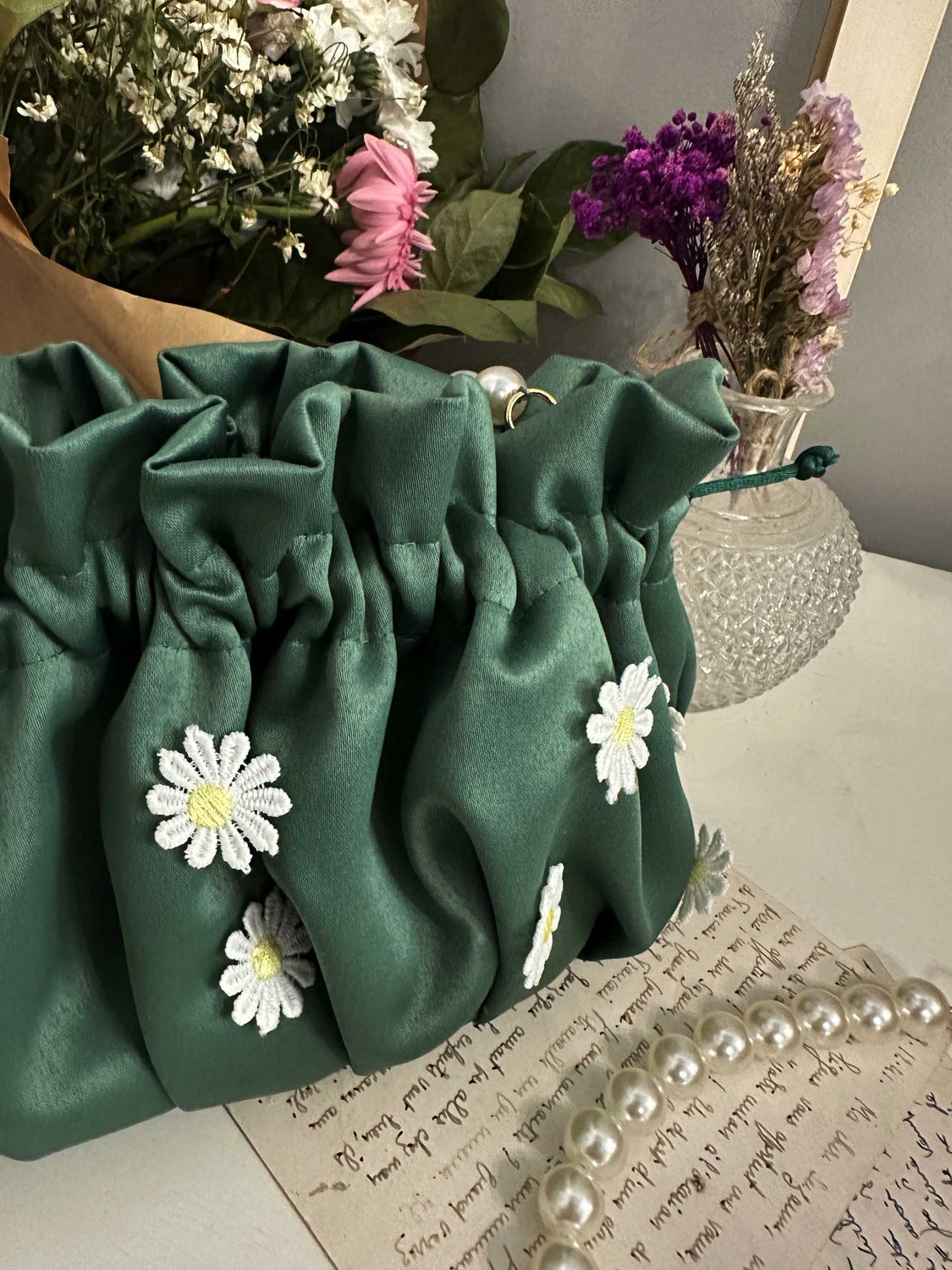 borsa sartoriale in raso verde con margherite bianche cucite in rilievo 